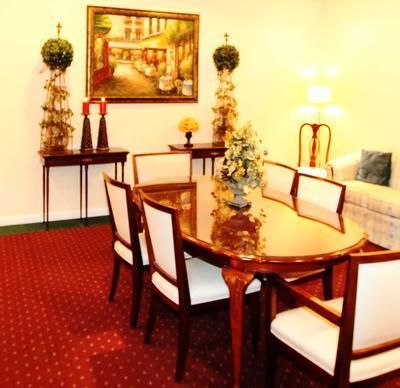 A dining room with a table and chairs and a painting on the wall