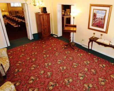 A living room with a red rug and a painting on the wall