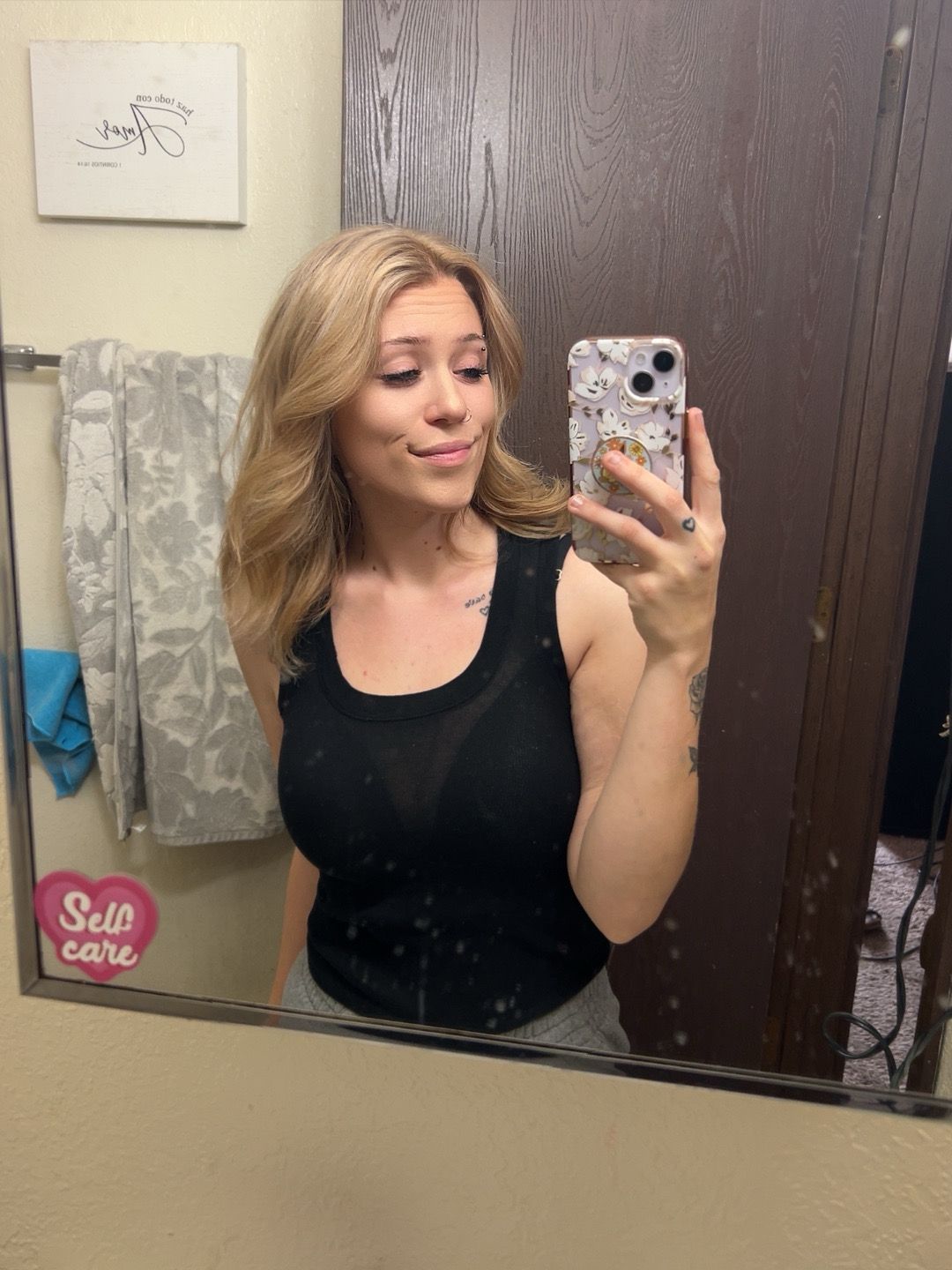 A woman is taking a selfie in a bathroom mirror.