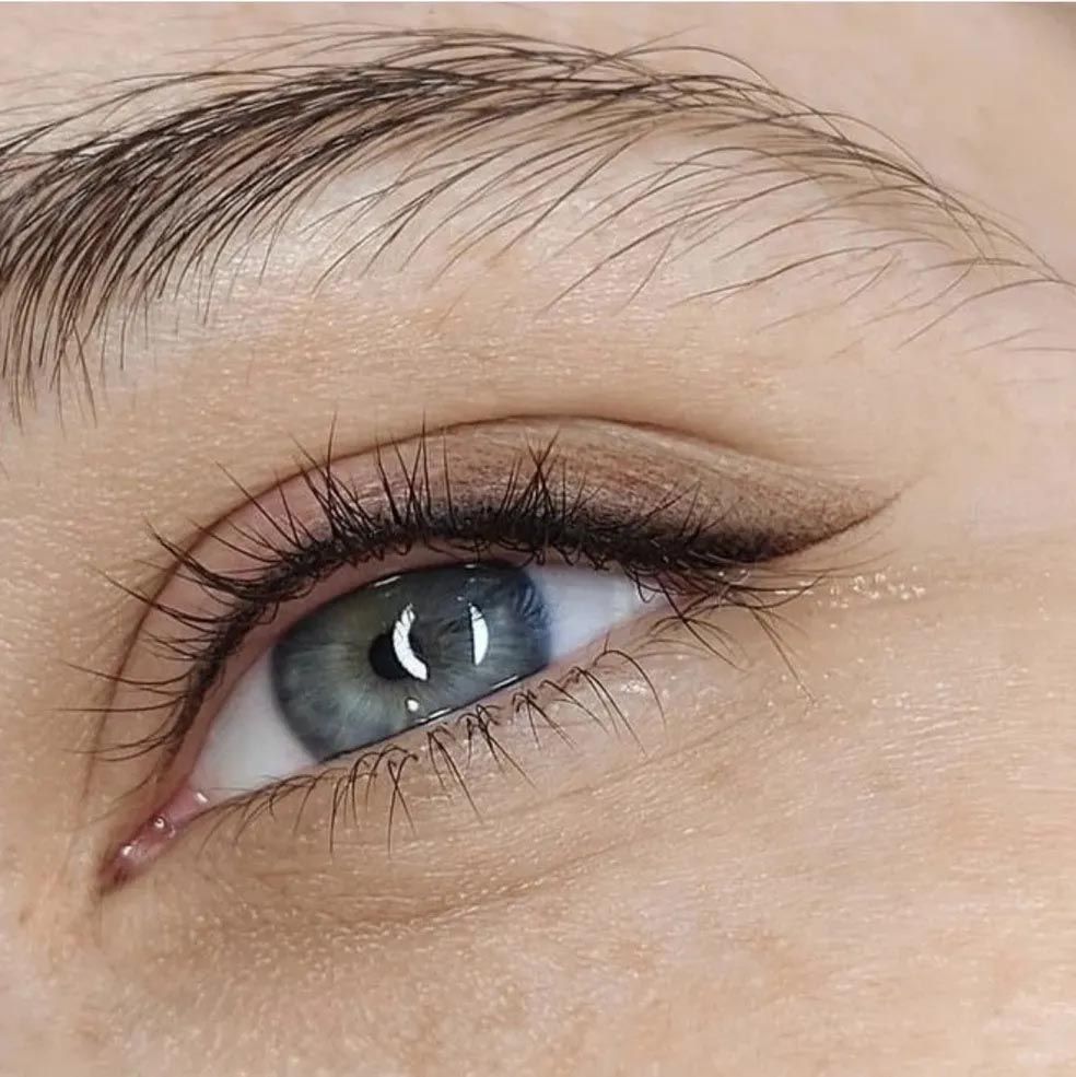 A close up of a woman 's eye with long eyelashes.
