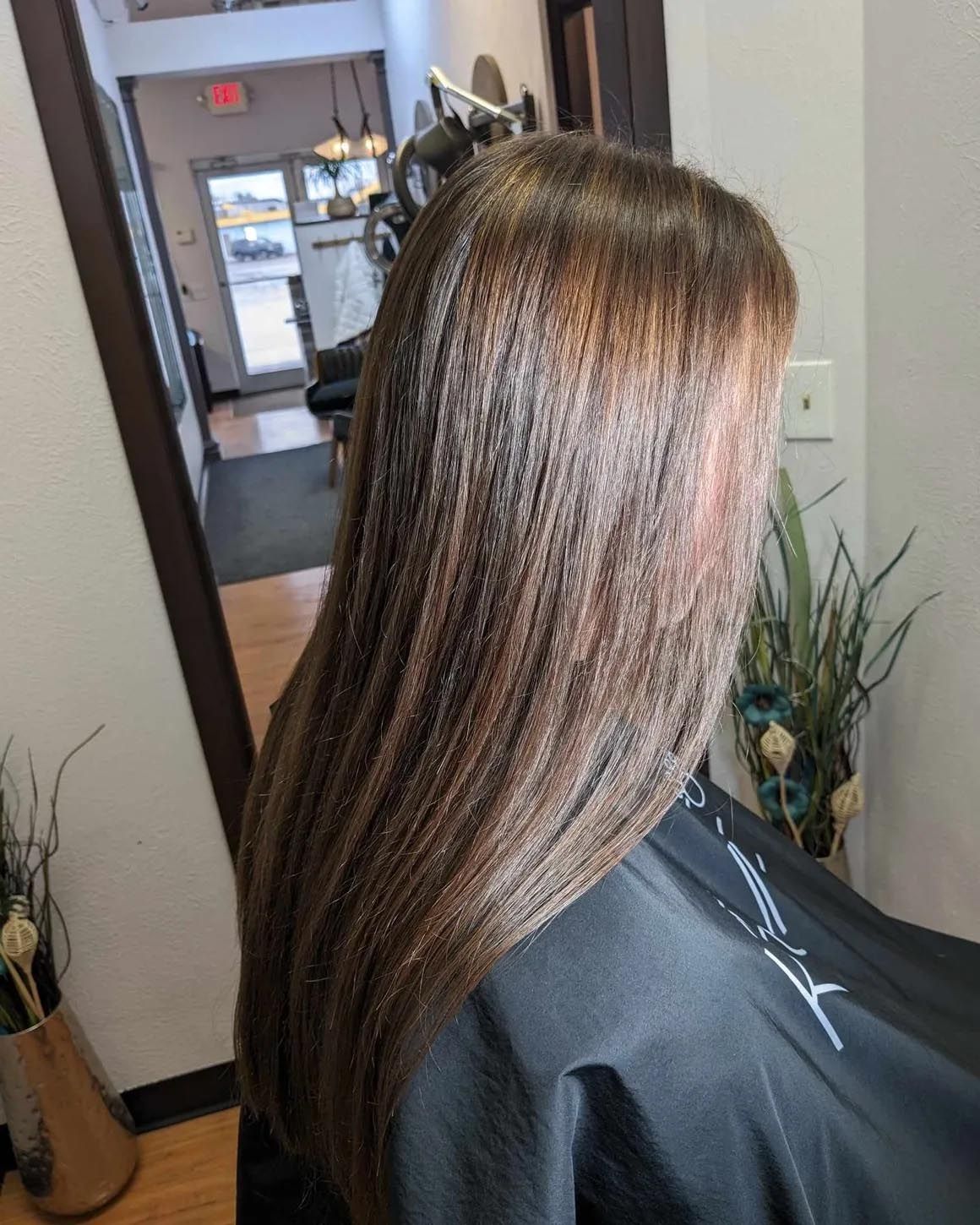 A woman is getting her hair cut in a salon.