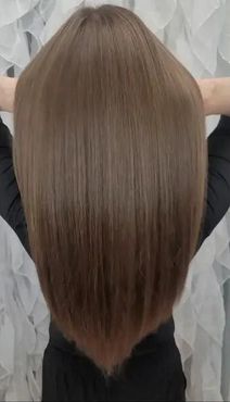 The back of a woman 's head with long brown hair.