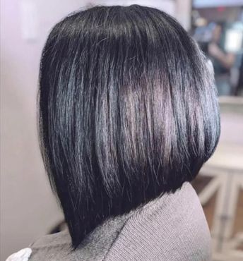 A woman is sitting in a chair with her hair in a bob.