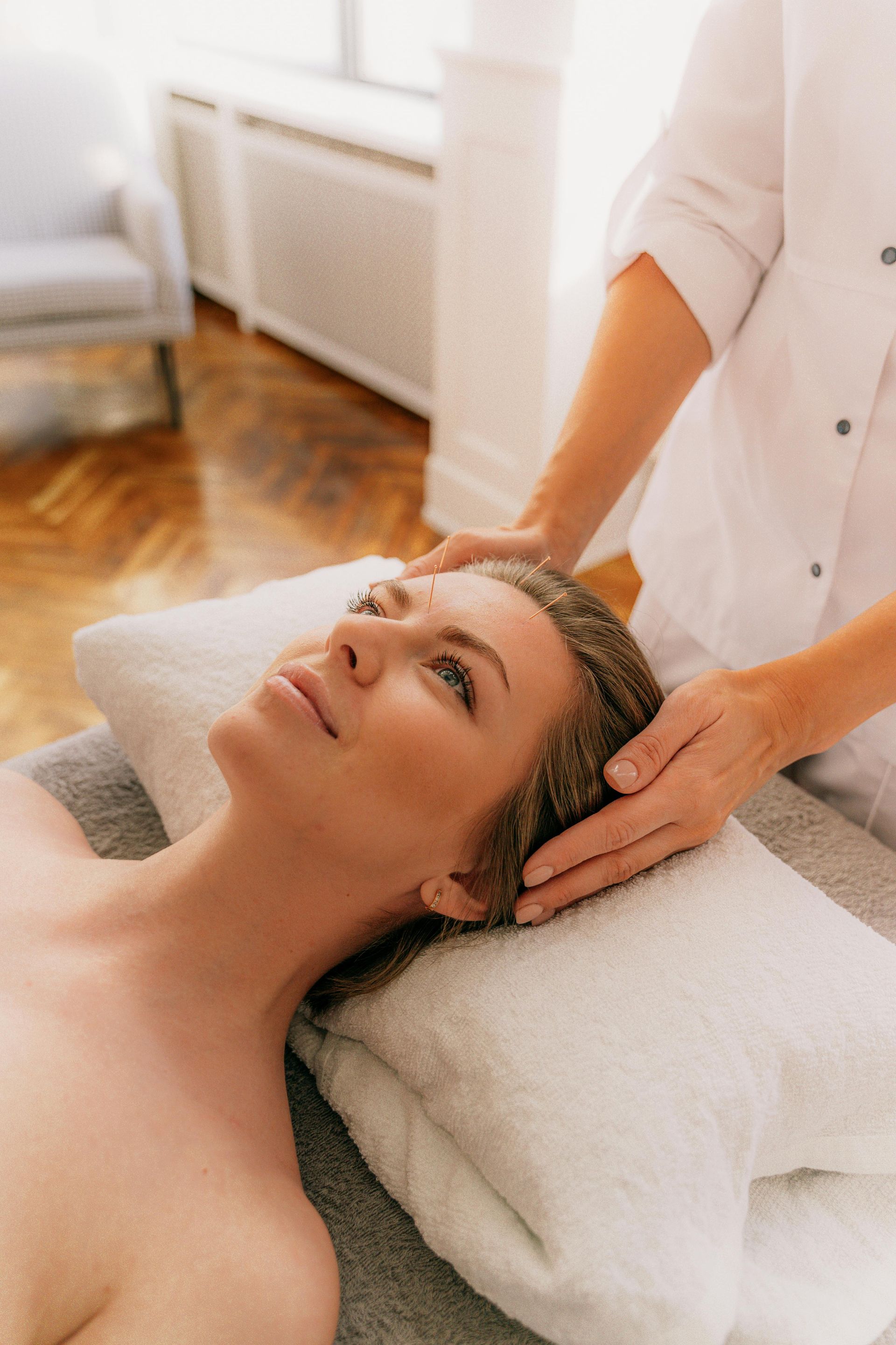 A woman is getting a head massage at a spa.