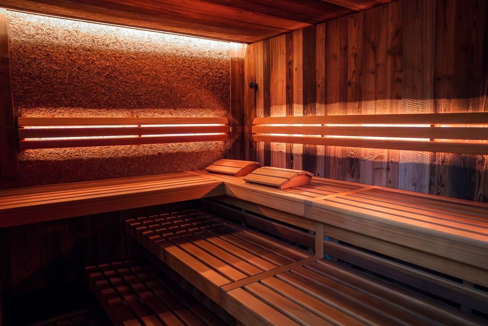 A wooden sauna with lights on the walls and benches.