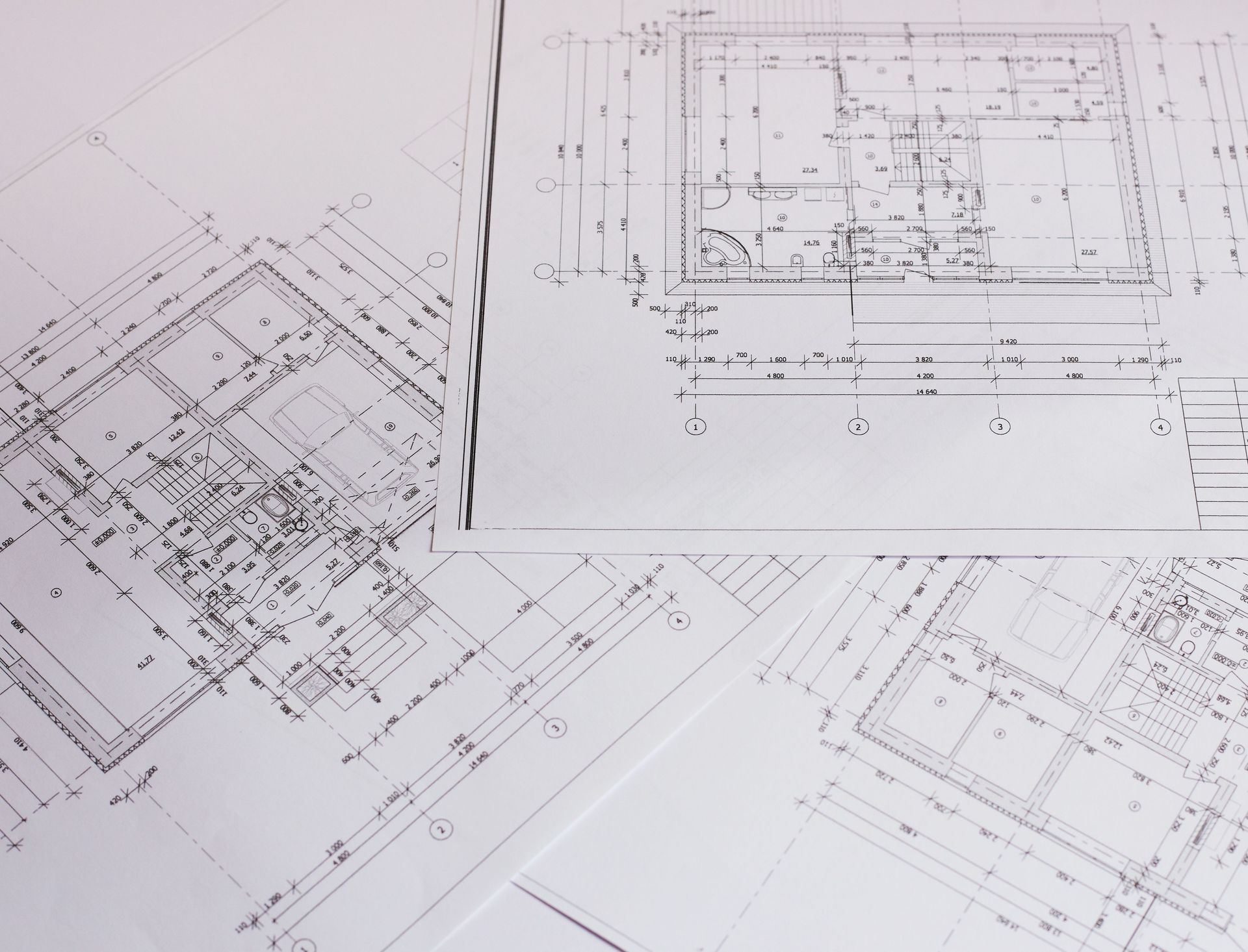 Architectural blueprints and floor plans spread across a white surface.