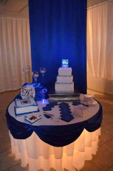 Round banquet table with blue-and-white dessert display and cake in a draped event hall