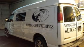 White wedding van with “Riding Green Weddings” branding parked in a garage.