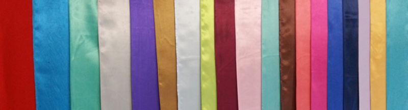 Colorful vertical striped fabric in red, blue, teal, purple, white, pink, and gold.