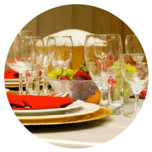 Elegant banquet table set with wine glasses, plates, and a fruit centerpiece