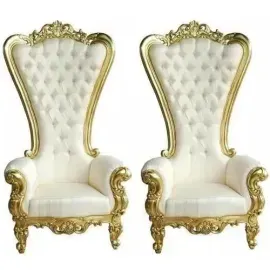 Pair of ornate white and gold upholstered throne-style chairs with tufted backs, side by side