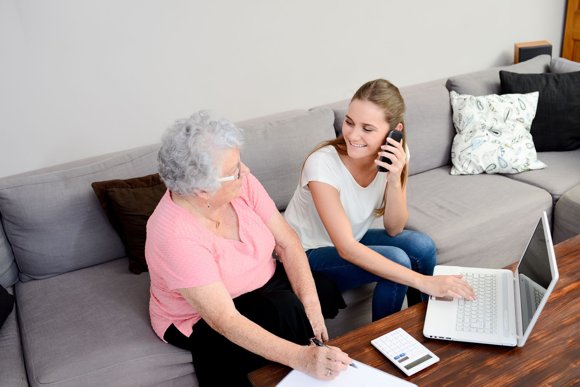 Real estate meeting with a house model, documents, calculator, and hands discussing a contract on a table