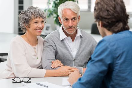 Three people in a meeting, with an older couple speaking to a man across the table Three people in a meeting, with an older couple speaking to a man across the table