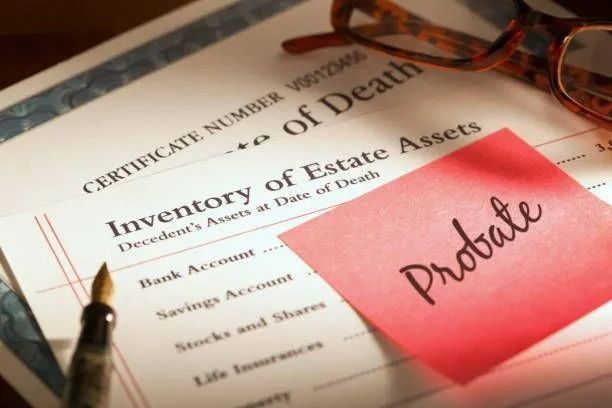 Estate documents with a red Probate note and eyeglasses on top Estate documents with a red Probate note and eyeglasses on top