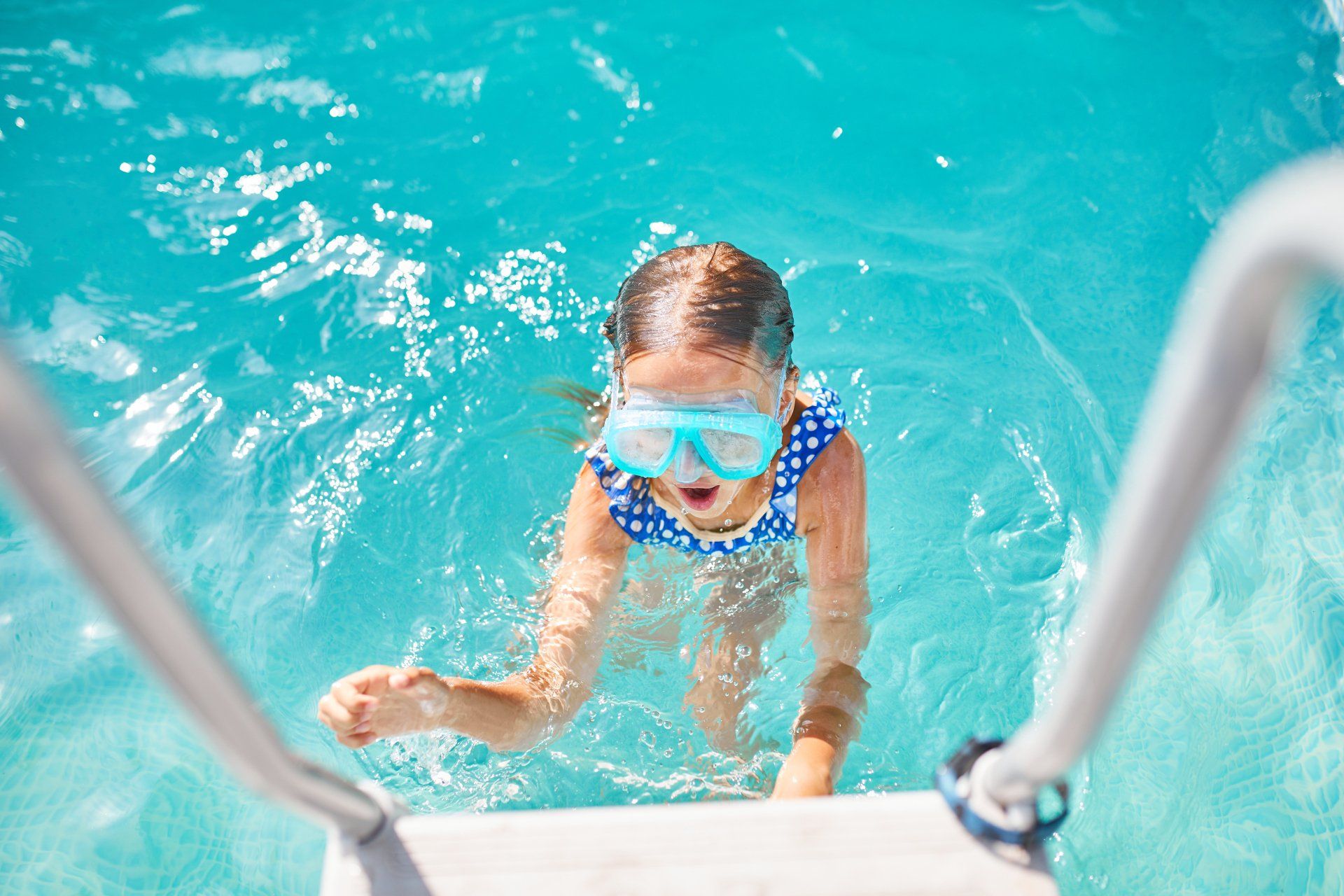  child in goggles on the steps climbing out