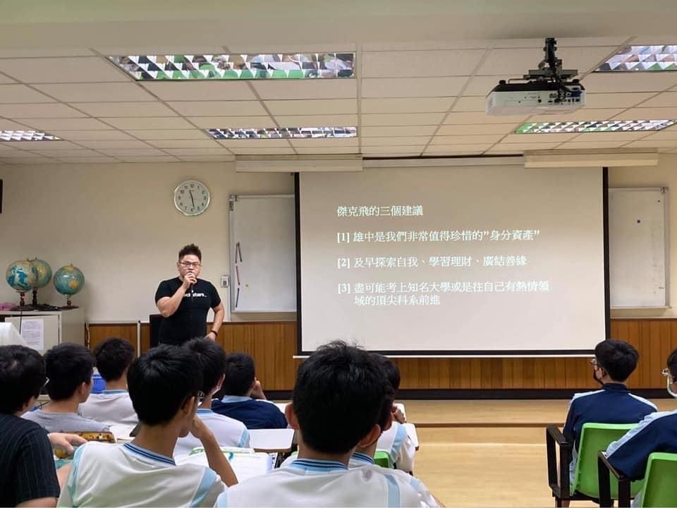 A man is giving a presentation to a group of students in a classroom.