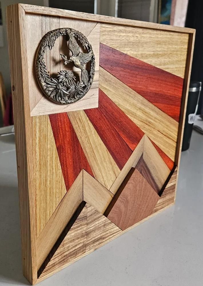 Wooden plaque with sunburst inlays and a small circular wolf carving in the upper left corner