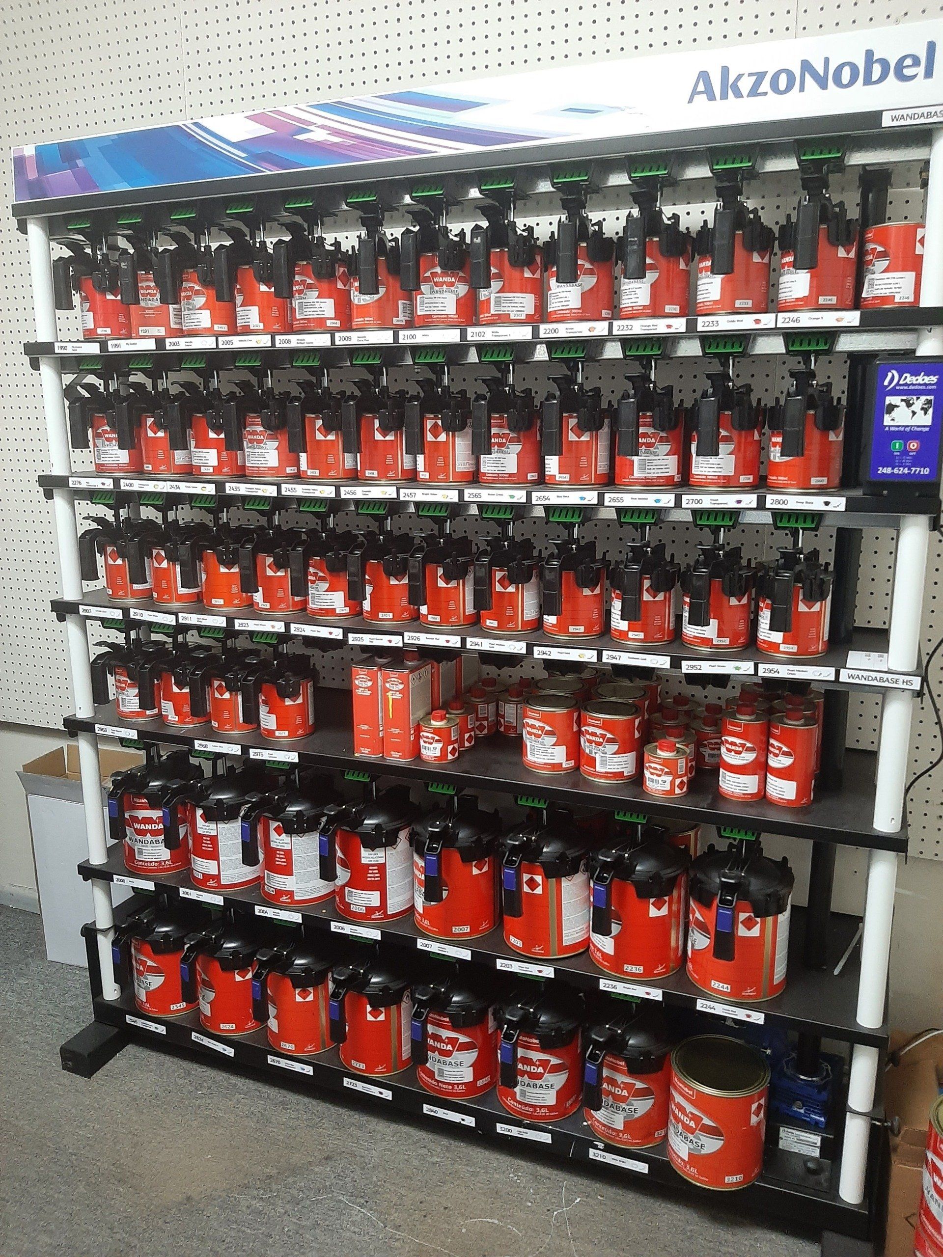 Retail shelf display of red and black AkzoNobel paint cans in a store aisle