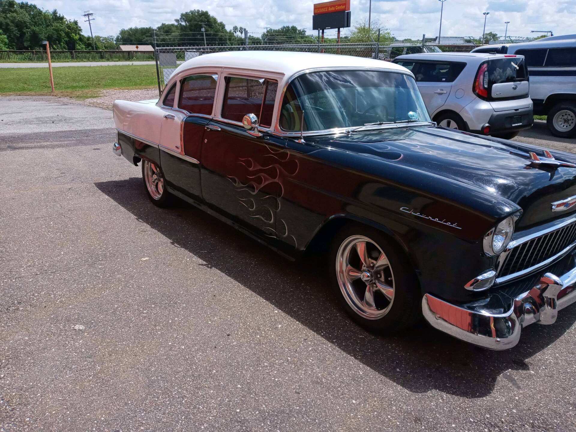 Classic black and red vintage car parked in a lot on a sunny day