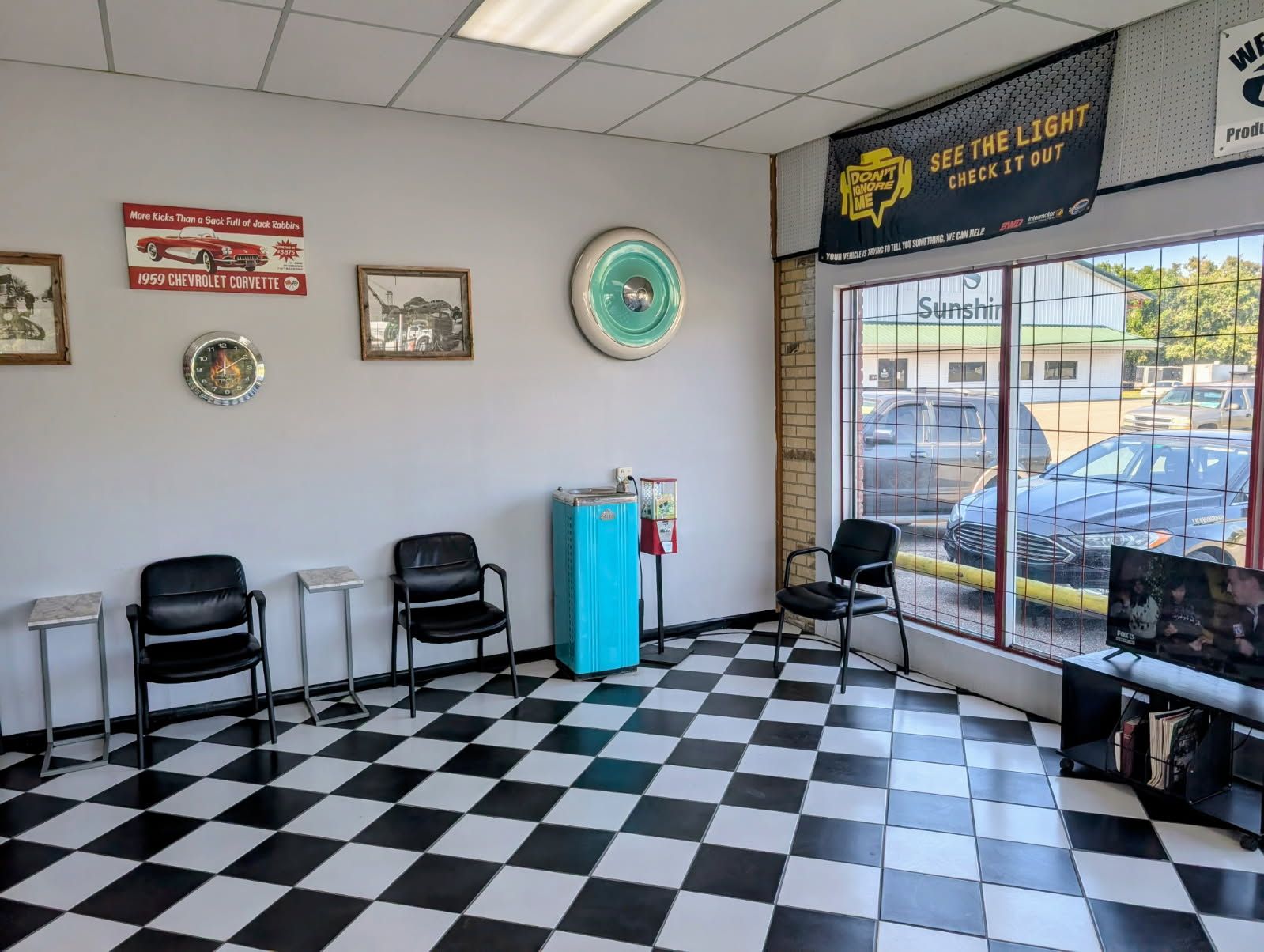 Empty barber shop interior with black-and-white checkered floor, chairs, and front windows.