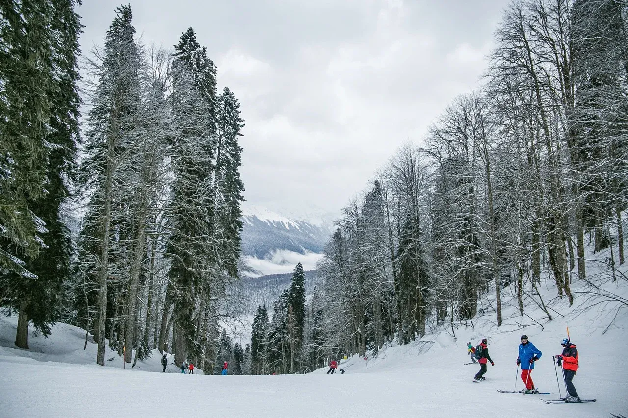 A group of people are skiing down a snow covered slope.