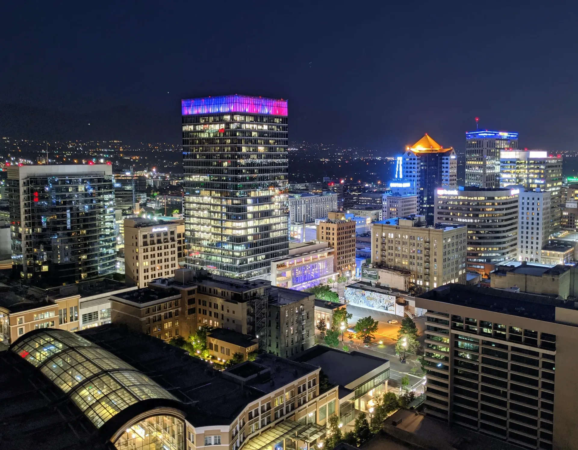 An aerial view of a city at night with lots of buildings lit up