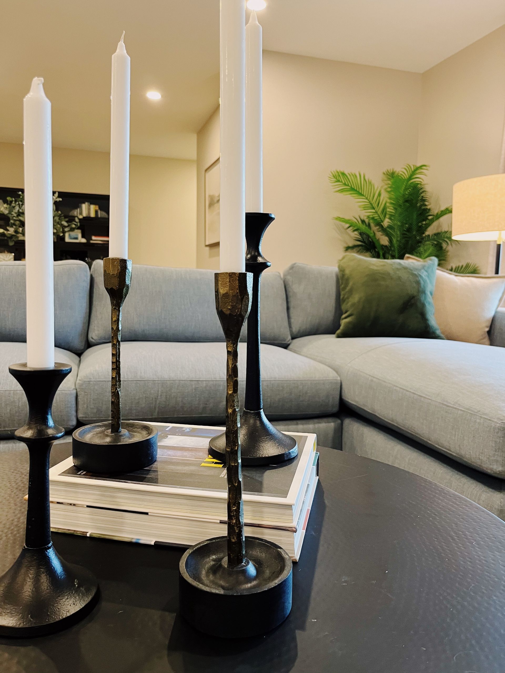 Modern living room with gray sectional sofa, black candleholders, and a tray on the coffee table