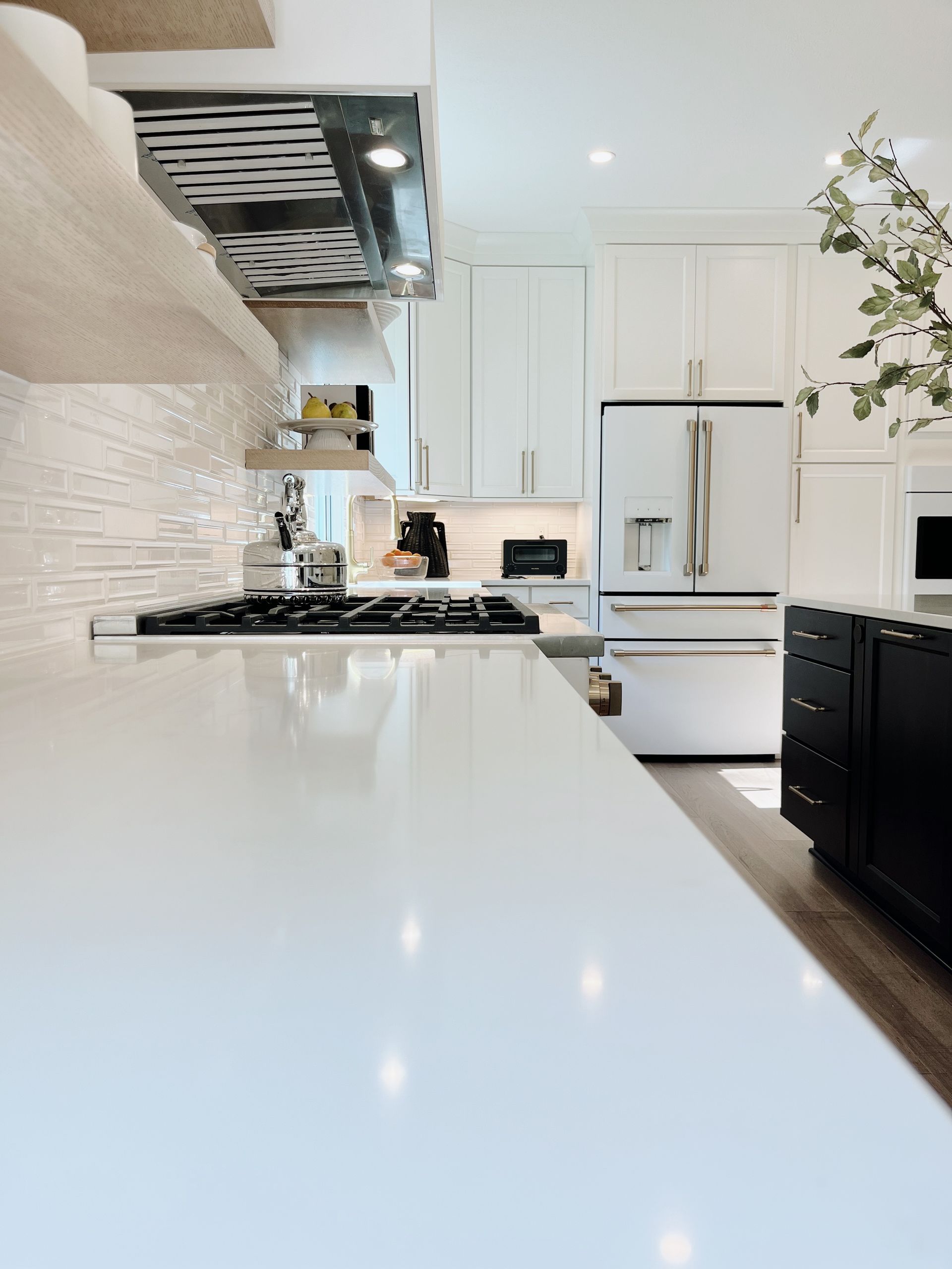 Bright modern white kitchen with a glossy island and stainless steel appliances
