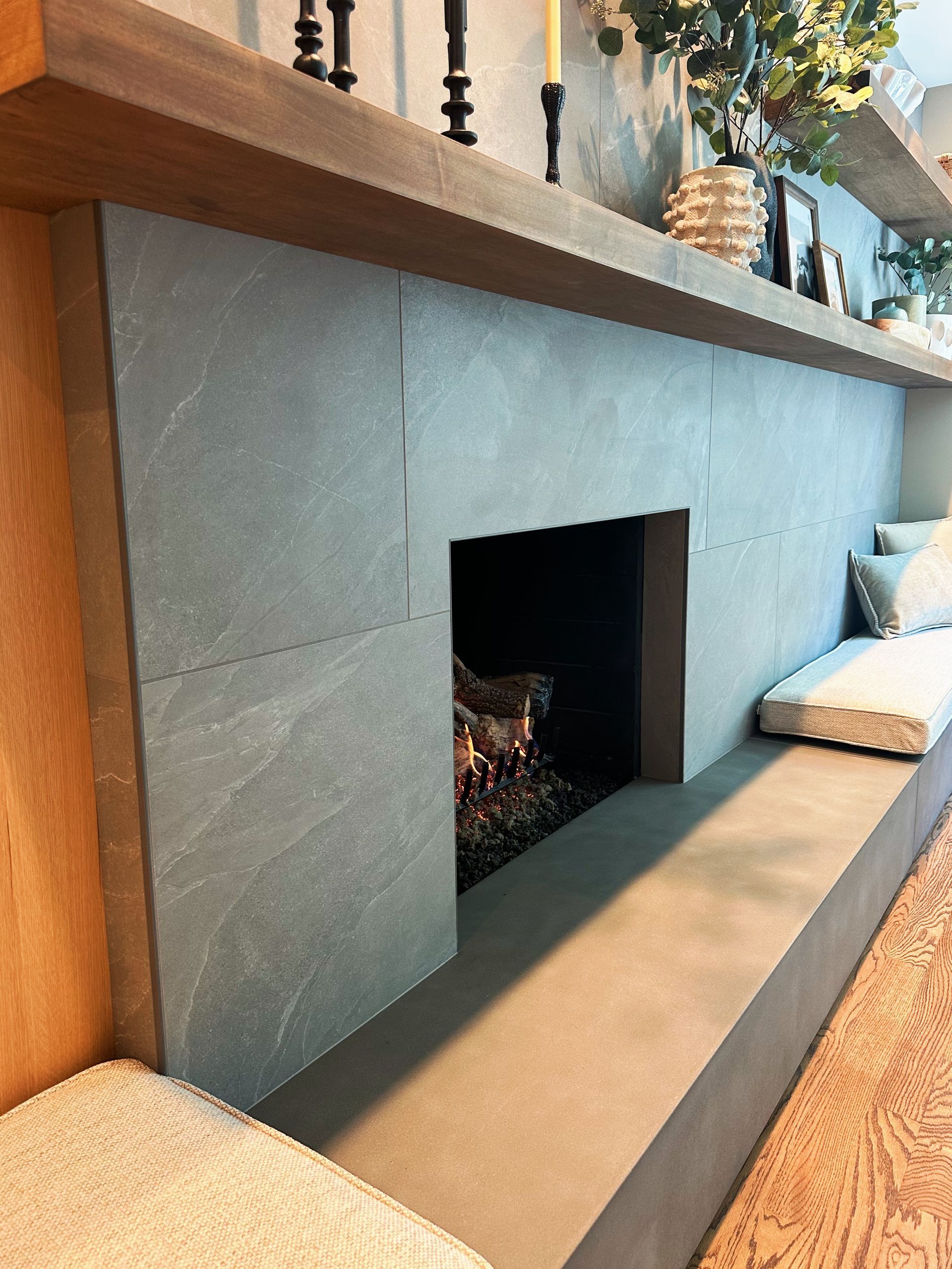 Modern black fireplace with gray surround and built-in bench seating in a cozy living room
