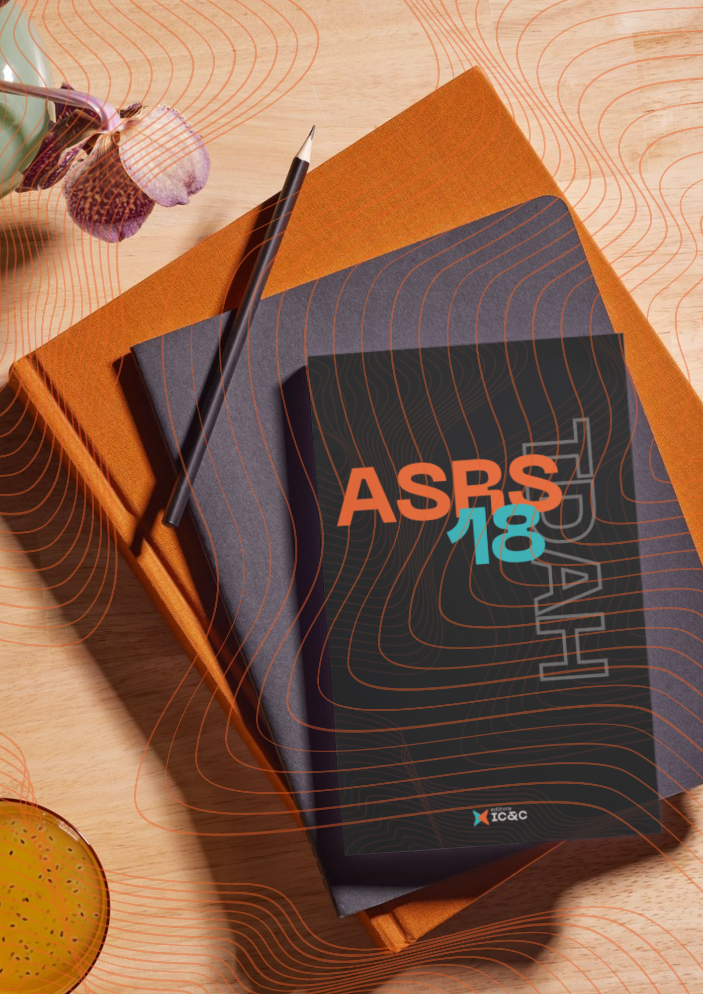 Caderno ASBS 18 com caneta sobre uma mesa laranja e preta, com decoração em tons quentes por perto.