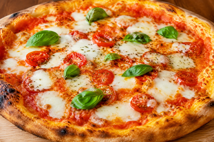 Pizza Margherita con mozzarella fusa, salsa di pomodoro e foglie di basilico fresco su un tagliere di legno.