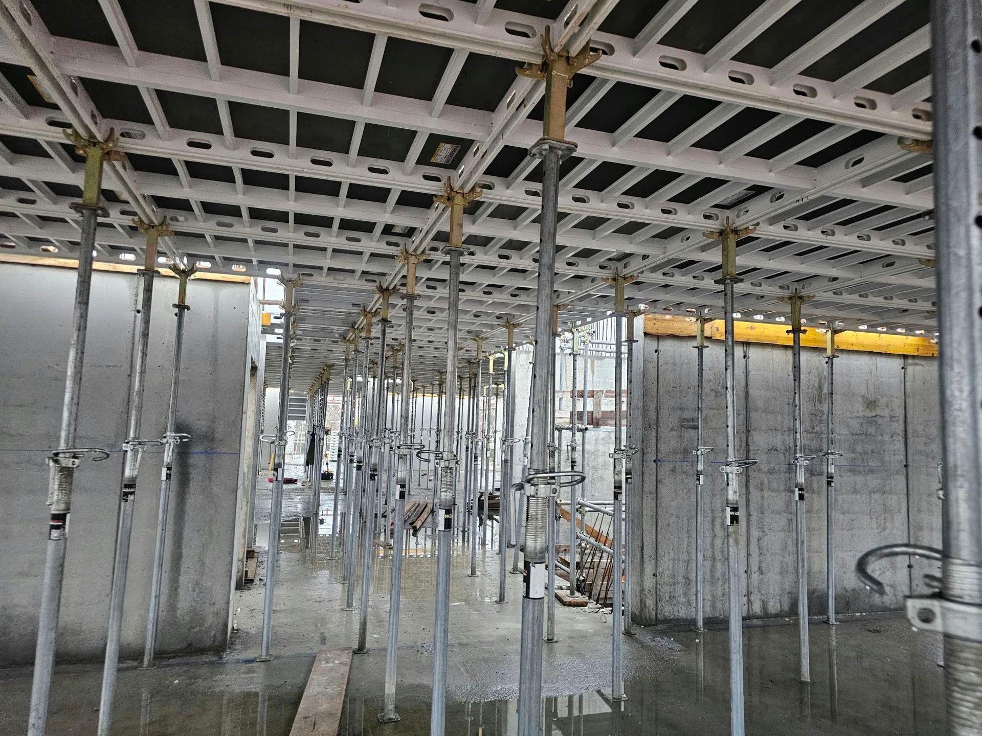 Cantiere al coperto con puntelli metallici e travi del soffitto a vista