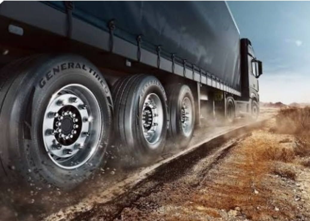 Heavy semi-truck driving on a dusty dirt road, close-up of its large wheels and trailer— Plateau Tyres in Alstonville, NSW