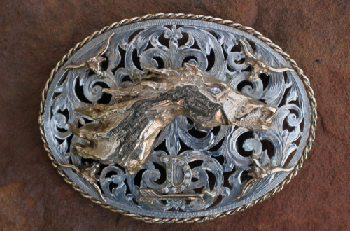 Silver and gold horse head belt buckle with ornate, openwork design.