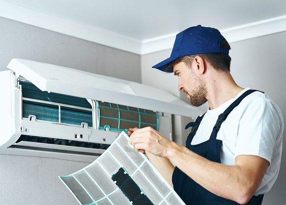 Man Cleaning Air Conditioner — Polk County, FL — Randolph’s AC/Heating Man Cleaning Air Conditioner — Polk County, FL — Randolph’s AC/Heating