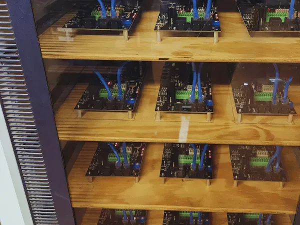A bunch of electronics are sitting on a wooden shelf