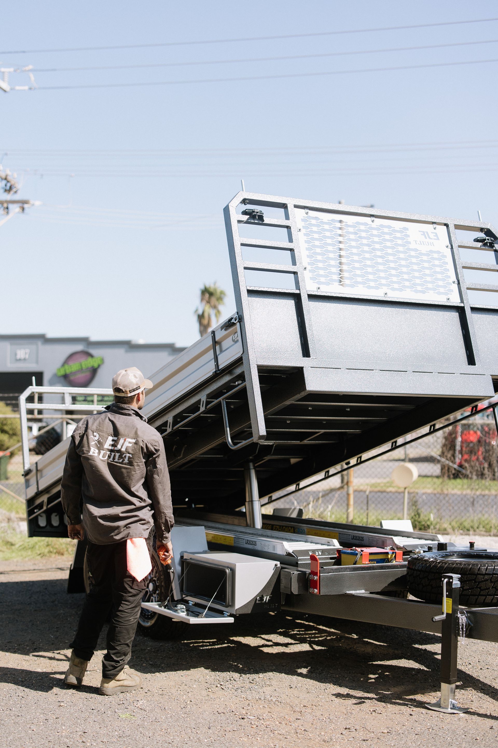 Man Inspecting a Black Trailer Bed — EJF Built in Dubbo, NSW