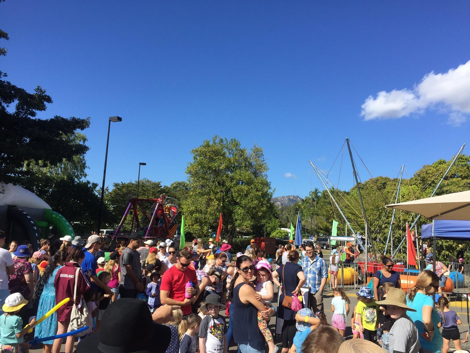 A Large Group Of People Are Gathered In A Park — Rides N Slides In Townsville, QLD