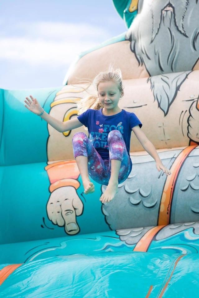 A Little Girl Is Jumping On A Bouncy House — Rides N Slides In Townsville, QLD