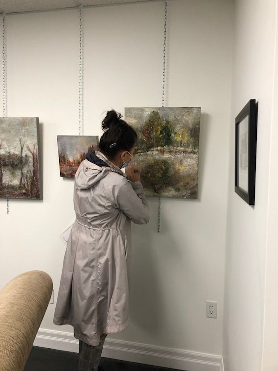 Collector viewing art on Gallery wall.