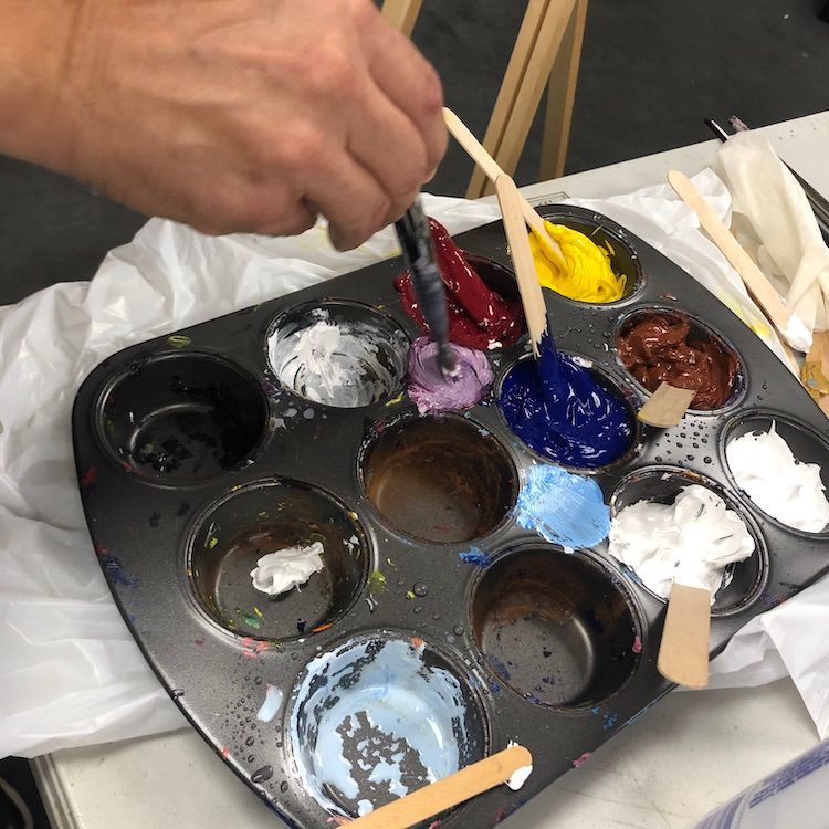 Detail photo of hand mixing paint.
