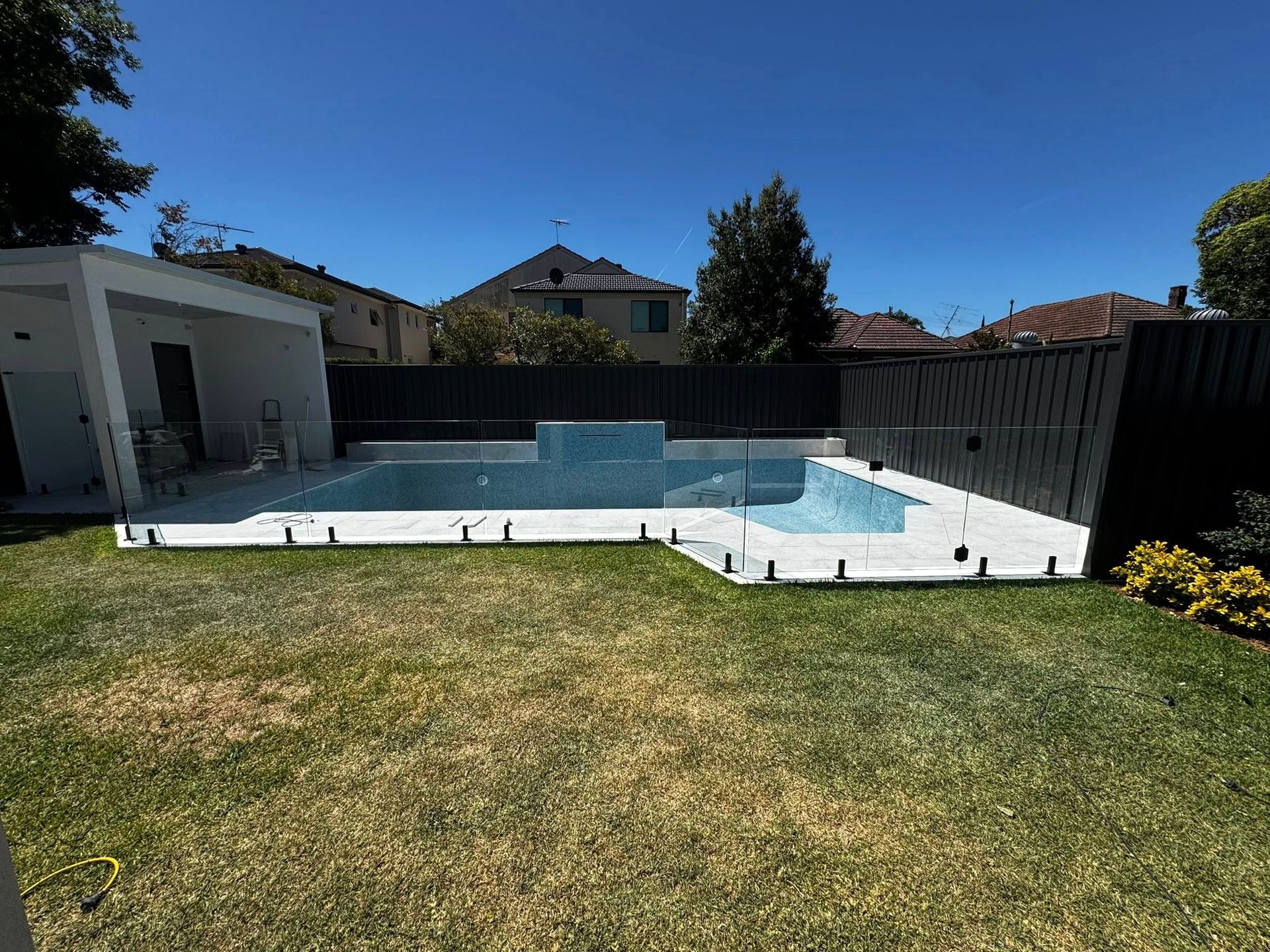 A House Backyard Swimming Pool With Light Blue Water — ClearView Glass Pool Fencing In Roselands, NSW
