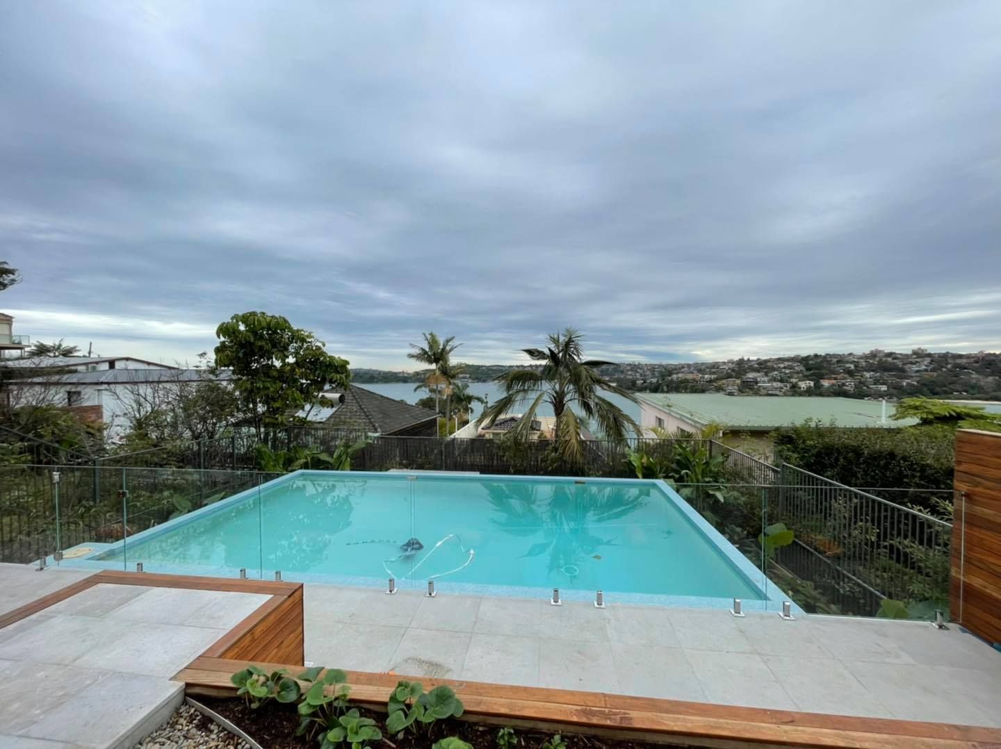 A Rectangular Backyard Swimming Pool With Light Blue Water — ClearView Glass Pool Fencing In Roselands, NSW
