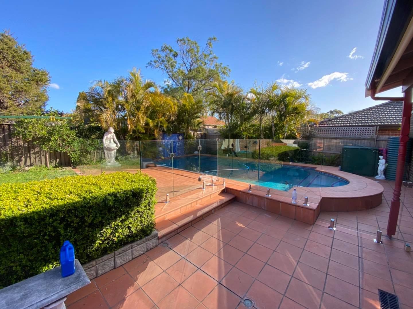 A Swimming Pool With Light Blue Water and Glass Fence — ClearView Glass Pool Fencing In Roselands, NSW