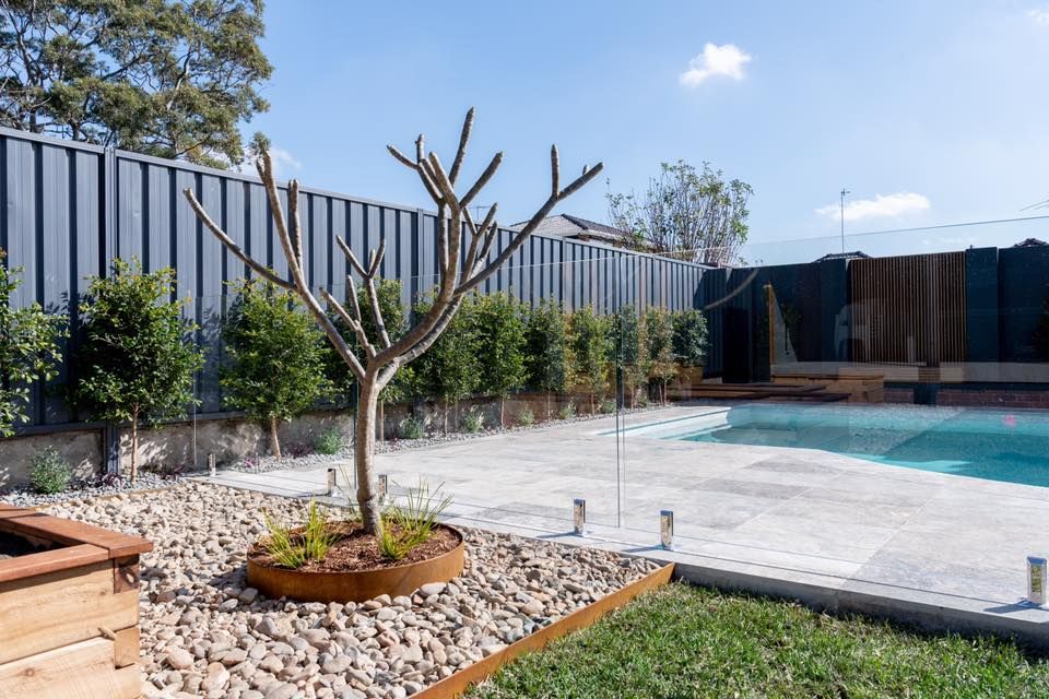 A Swimming Pool With Stone Pavers — ClearView Glass Pool Fencing In Roselands, NSW