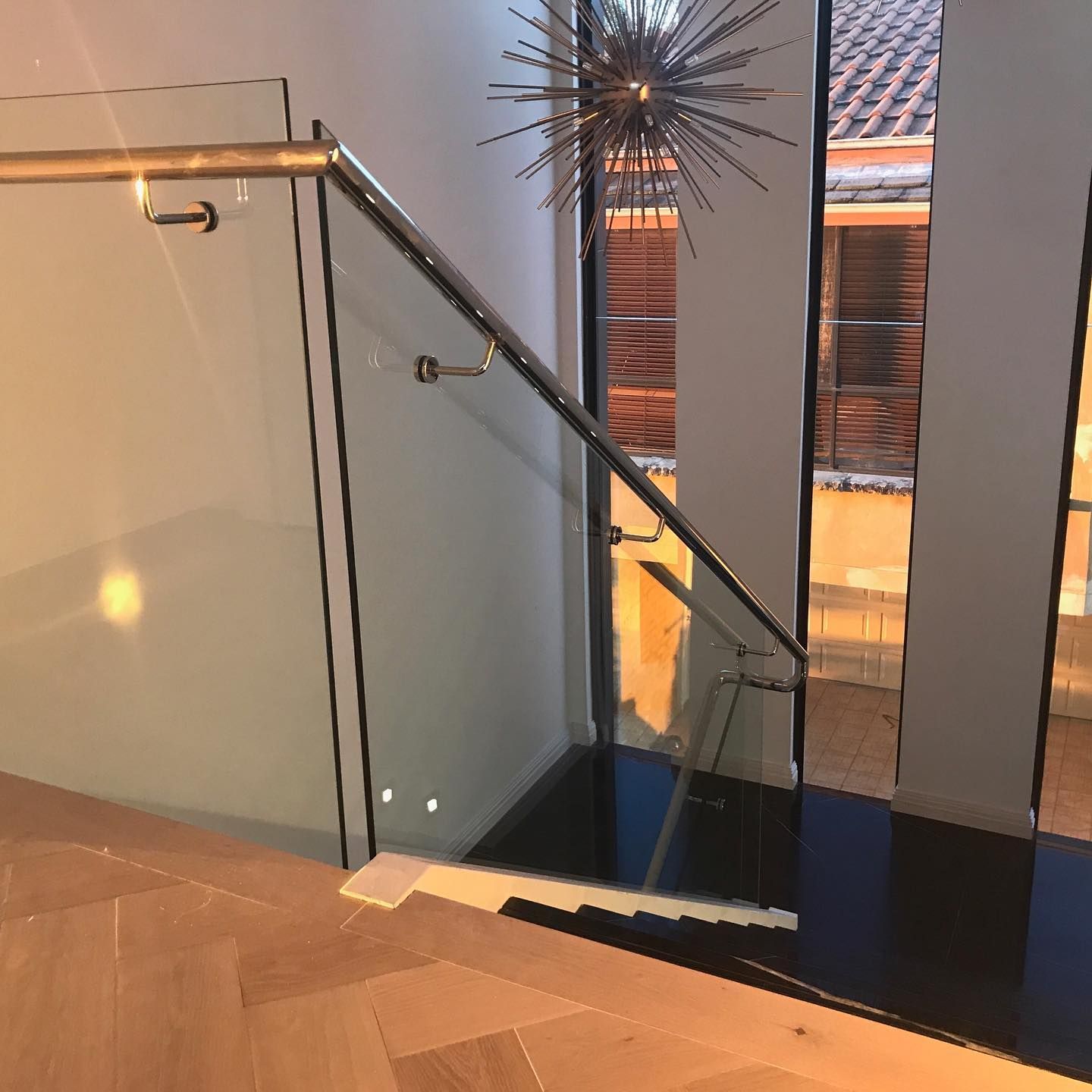 Staircase with glass railing and warm lighting in a modern interior — ClearView Glass Pool Fencing In Roselands, NSW