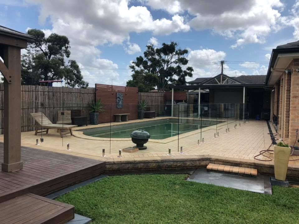 A Rectangular Backyard Swimming Pool With Glass Fencing — ClearView Glass Pool Fencing In Roselands, NSW