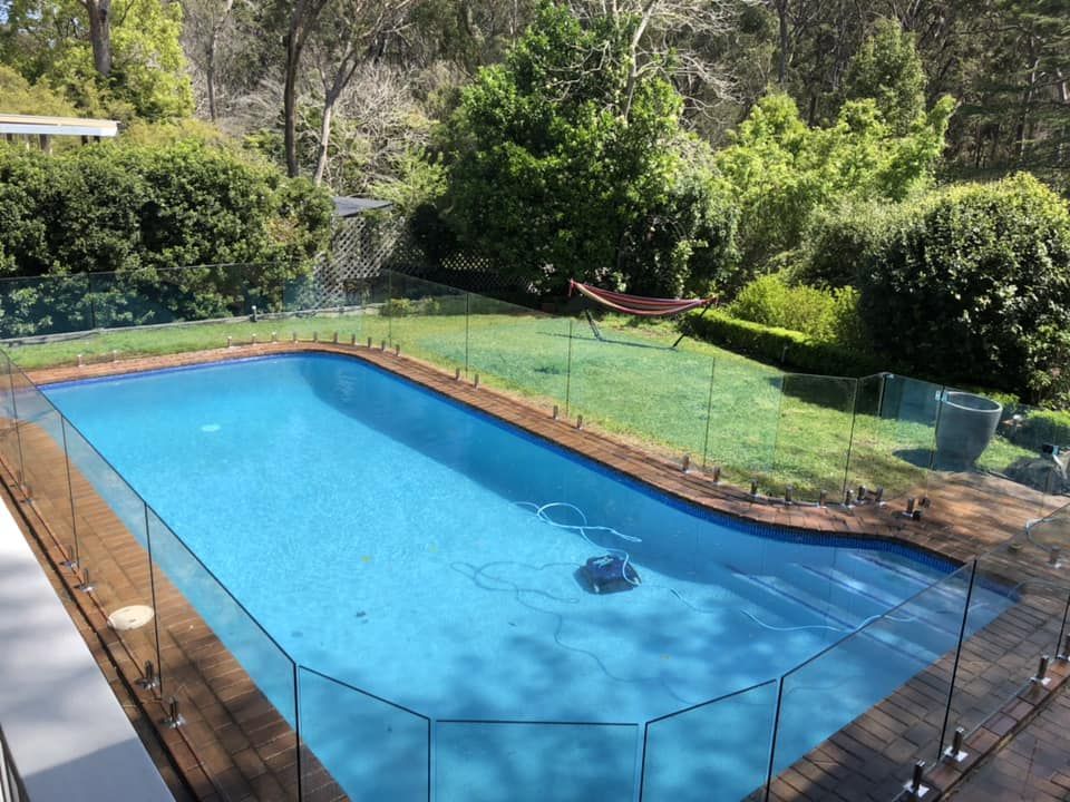 A Rectangular Backyard Swimming Pool With Light Blue Water — ClearView Glass Pool Fencing In Roselands, NSW