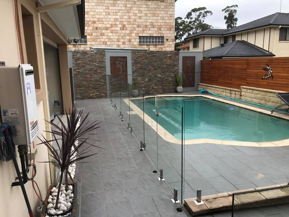 A Rectangular Backyard Swimming Pool With Light Blue Water — ClearView Glass Pool Fencing In Roselands, NSW