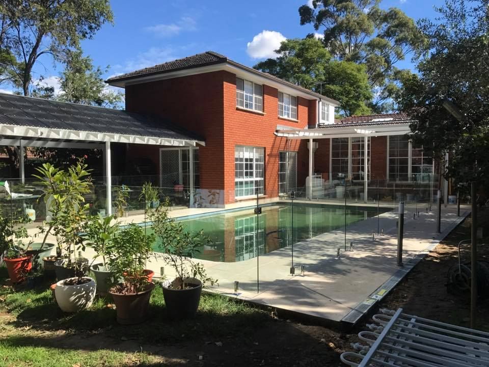 A Rectangular Backyard Swimming Pool And Has Glass Fence — ClearView Glass Pool Fencing In Roselands, NSW